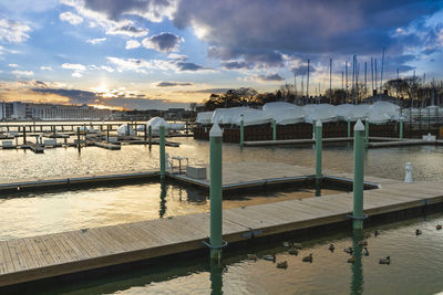 Pier over sea against sky during sunset