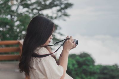 Midsection of woman holding hands against blurred background