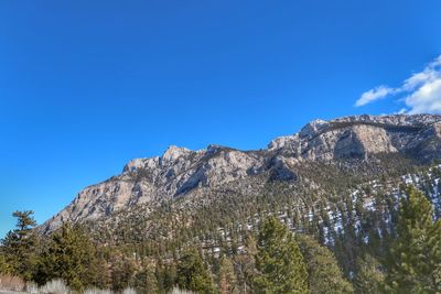 Low angle view of mountains against clear blue sky