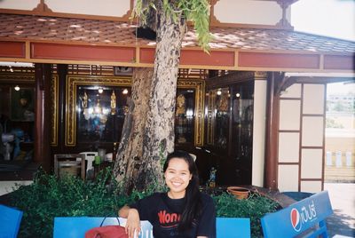Portrait of smiling young woman sitting at restaurant