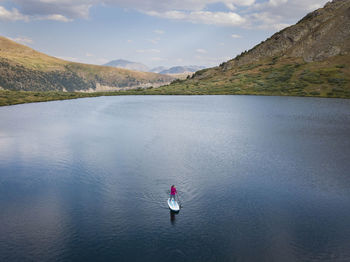 Aerial view of woman paddleboarding in lake
