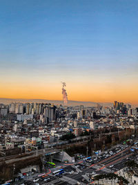 High angle view of illuminated cityscape against sky during sunset