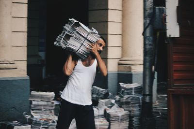 Woman holding umbrella standing on street in city