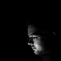 Close-up portrait of man against black background