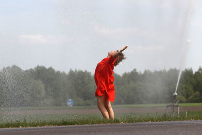 Full length of woman standing on field against sky