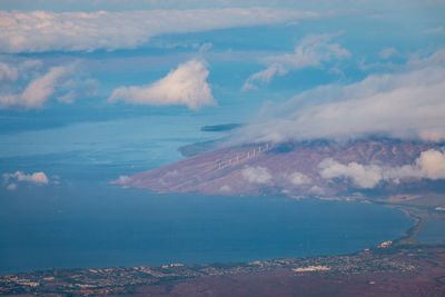 Aerial view of sea and mountains, westcoast landscape maui with modern windmills against sky