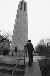 Full length rear view of man standing against the sky