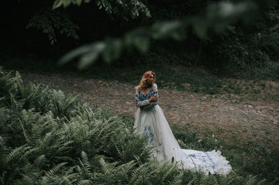 Bride standing by plants