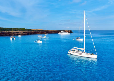 Sailboats on sea against sky