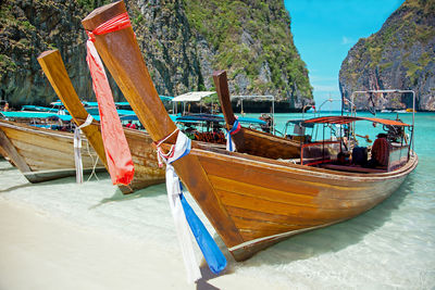 Boats moored on beach against sky