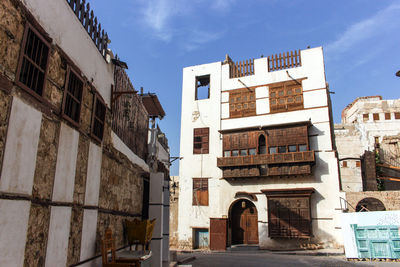 Low angle view of buildings in town against sky