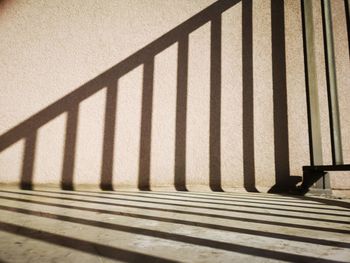 High angle view of shadow of railing on staircase