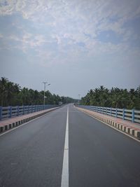 Empty road against cloudy sky