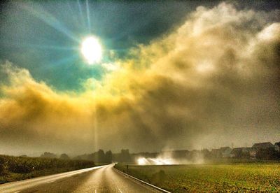 Country road against cloudy sky