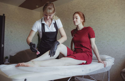 Young woman sitting on bed at home