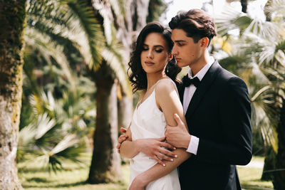 A beautiful couple in love, bride and groom in wedding clothes, walk and pose in the park in nature