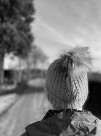 Black and white rear view of woman wearing a knitted hat