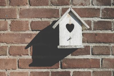 Close-up of birdhouse on brick wall