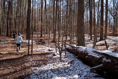 Full length of person on snow covered land in forest