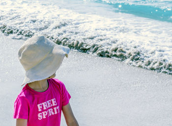 Girl wearing hat while standing at beach