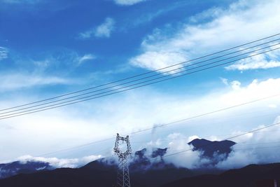 Low angle view of silhouette electricity pylon against sky