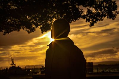 Silhouette woman standing against sky during sunset