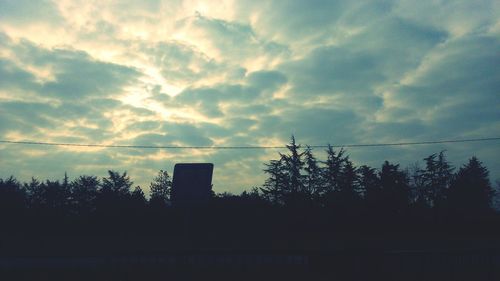 Low angle view of silhouette tree against cloudy sky