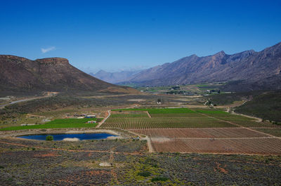 Scenic view of agricultural field against clear blue sky