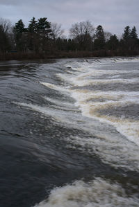 Scenic view of waterfall against sky