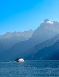 Scenic view of sea and mountains against blue sky