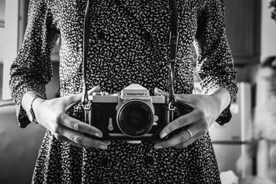 Midsection of woman holding camera