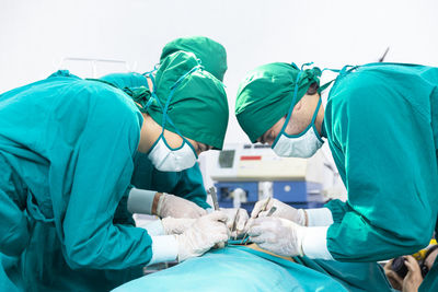 Doctors are treating patients in operating rooms. the surgeon team is working in the operating room.