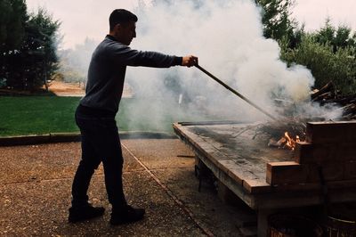 Full length of man burning wood outdoors