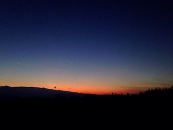 Silhouette landscape against clear sky during sunset