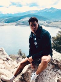 Portrait of young man sitting on rock