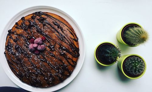 Directly above shot of cake in plate by plants on table