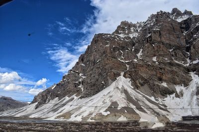 Scenic view of snowcapped mountains against cloudy sky