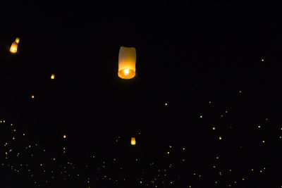 Low angle view of illuminated lights against sky at night