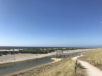 Scenic view of beach against clear blue sky