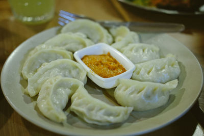 Close-up of dim sum and dip in plate