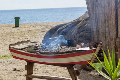 Firewood burning in boat at beach