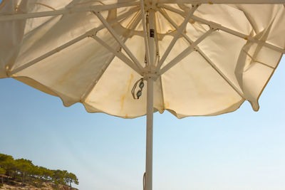 Low angle view of umbrella against blue sky