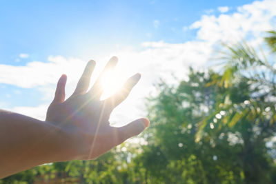 Low angle view of hand against sky