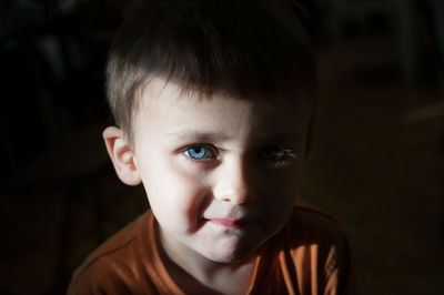 Close-up portrait of cute boy in darkroom