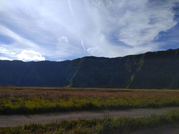 Scenic view of land and mountains against sky