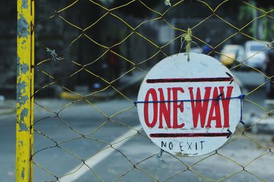 Close-up of text on chainlink fence