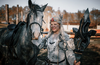 Portrait of woman with horse standing on field