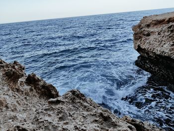 Scenic view of rocks in sea against sky