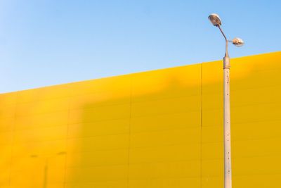 Low angle view of street light against yellow building