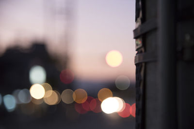 Defocused image of illuminated city against sky